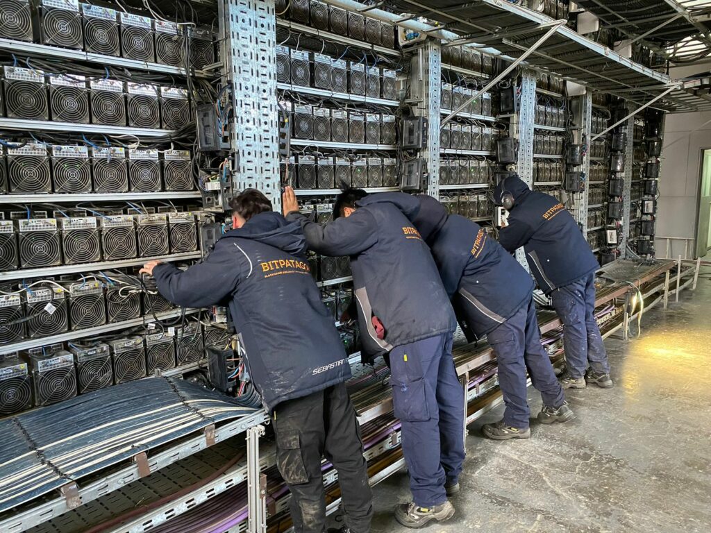 Empleados de Bitpatagonia realizando mantenimiento de equipos ASIC